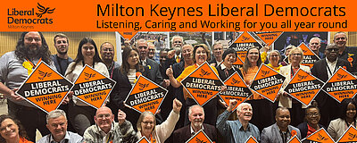 A photograph of Liberal Democrats following the 2026 local election count, holding diamond posters saying "winning here"